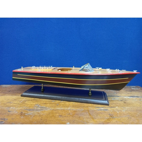 126 - A WOODEN MODEL OF A SPEED BOAT on a hardwood stand 17cm (h) x 60cm (w) x 18cm (d)