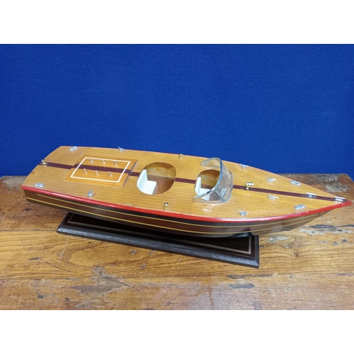 126 - A WOODEN MODEL OF A SPEED BOAT on a hardwood stand 17cm (h) x 60cm (w) x 18cm (d)