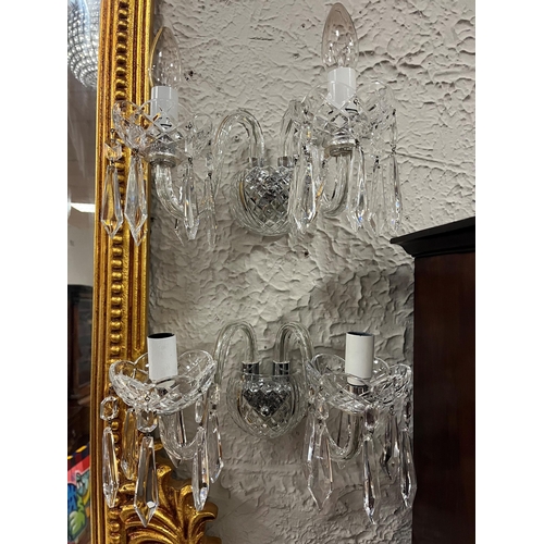 536 - A PAIR OF WATERFORD CUT GLASS TWO BRANCH WALL LIGHTS hung with faceted pendants