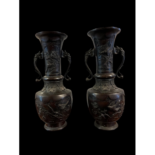 285 - A PAIR OF VINTAGE CHINESE BRONZE VASES with phoenix bird handles raised on a circular spreading foot... 