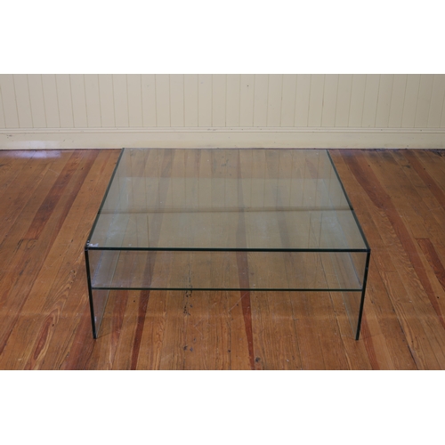 405 - A MODERN GLAZED COFFEE TABLE of rectangular outline the shaped plate on glazed supports joined by an... 