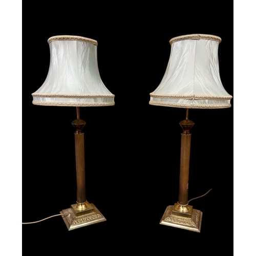 429 - A PAIR OF BRASS TABLE LAMPS each with a reeded column above a square stepped base with shades 73cm (... 