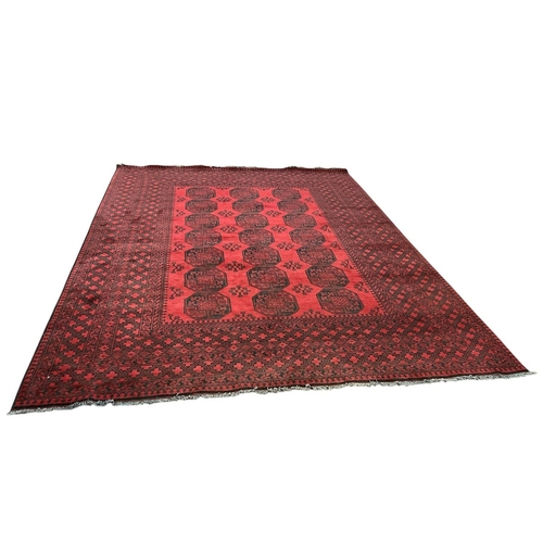 545 - A BOKHARA WOOL RUG the wine and indigo ground with central panel filled serrated panels and palmette... 