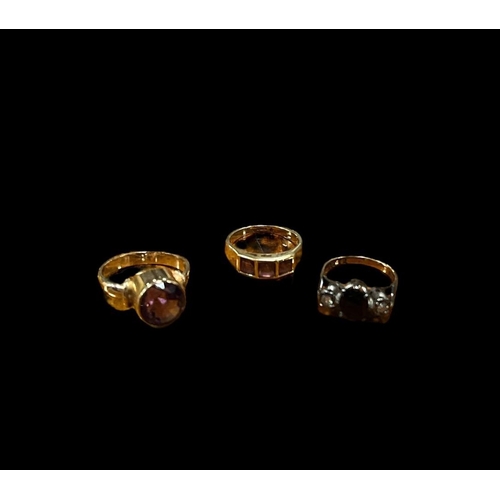 553 - THREE 9CT GOLD DRESS RINGS to include an amethyst size R, a three stone dress ring size K, a jet sto... 