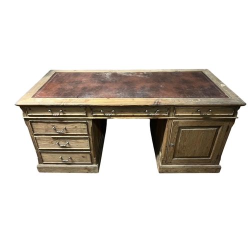 559 - A PINE PEDESTAL DESK the rectangular top inset with writing surface above three frieze drawers raise... 