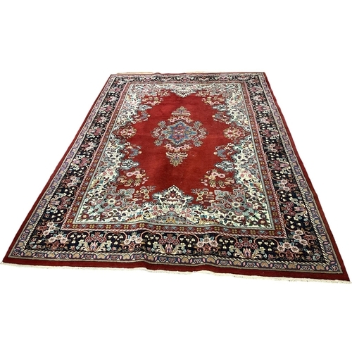 546 - A KERMAN WOOL RUG the wine, beige and indigo ground with central panel filled with stylised flowerhe... 