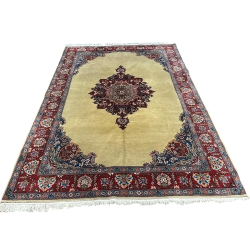 544 - A TABRIZ WOOL RUG the beige, wine and light blue ground with central panel filled with a foliate and... 