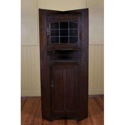 565 - A VINTAGE OAK CORNER CABINET the three quarter moulded gallery above a lead glass door containing a ... 