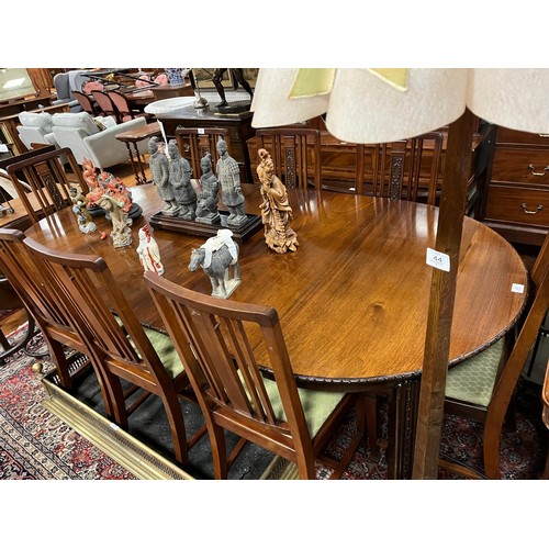 47 - A VINTAGE MAHOGANY DINING TABLE of rectangular outline with rounded ends and three loose leaves on c... 