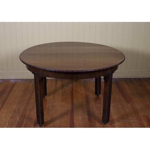 90 - A VINTAGE MAHOGANY DINING TABLE of rectangular outline with rounded ends and three loose leaves on c... 