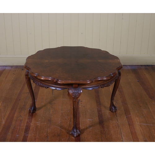 94 - A VINTAGE WALNUT COFFEE TABLE the circular shaped top with carved apron on cabriole legs with claw a... 