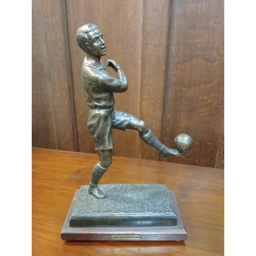 296 - A BRONZE FIGURE modelled as a footballer shown standing on one leg raised on a hardwood base 33cm (h... 