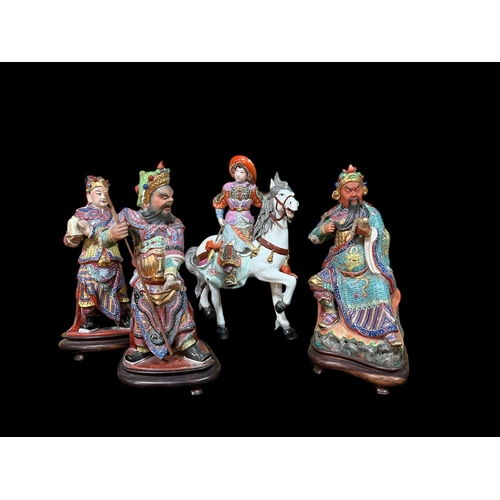 493 - THREE VINTAGE CHINESE FAMILLE ROSE FIGURES modelled as a scholar, a warrior and an emperor each rais... 