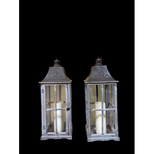 116 - A PAIR OF PINE GREY PAINTED AND METAL CANDLE LANTERNS each with a shaped metal hood above an astraga... 