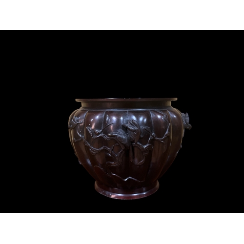 118 - A JAPANESE BRONZE URN of cylindrical tapering form moulded in high relief, with birds and foliage 27... 