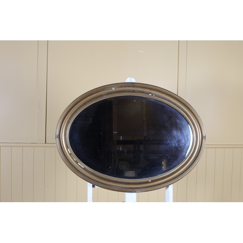 148 - A VINTAGE GILT FRAME MIRROR the oval bevelled glass plate within a reeded strapwork frame 46cm (h) x... 