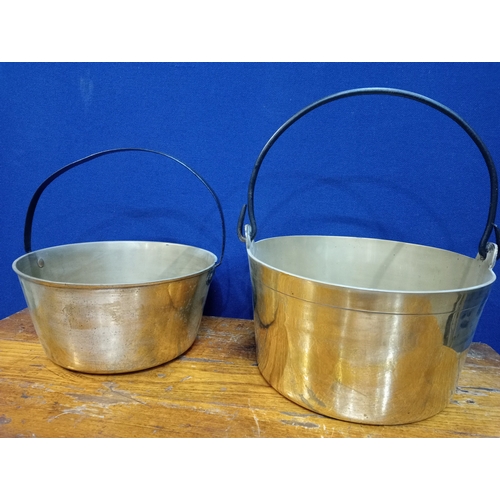 280 - TWO BRASS SKILLETS each of cylindrical tapering form with steel carrying handles The larger 18cm (h)... 