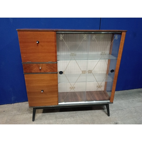 294 - A RETRO TEAK AND GLAZED CABINET the rectangular shaped top above a pair of glazed sliding doors flan... 