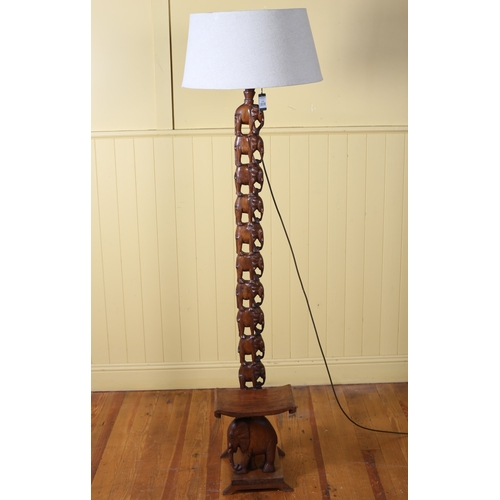 31 - A BURMESE HARDWOOD STANDARD LAMP the central column carved with elephants above a shaped seat with s... 