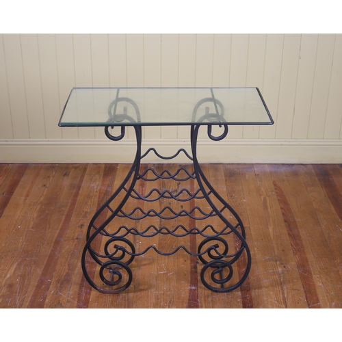 408 - A WROUGHT IRON AND GLAZED OCCASIONAL TABLE the rectangular glazed top raised on scroll supports join... 