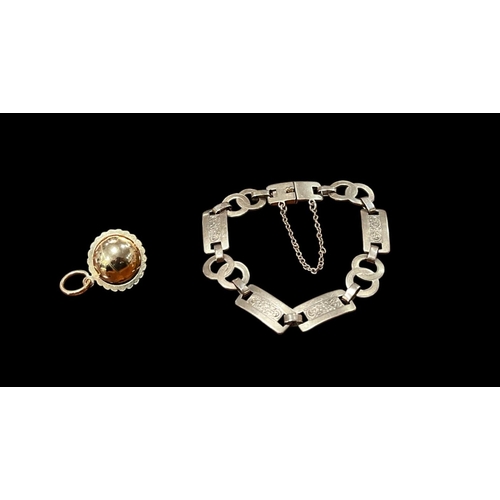 555A - A 9CT GOLD FLATLINK BRACELET together with A PENDANT in the form of a globe