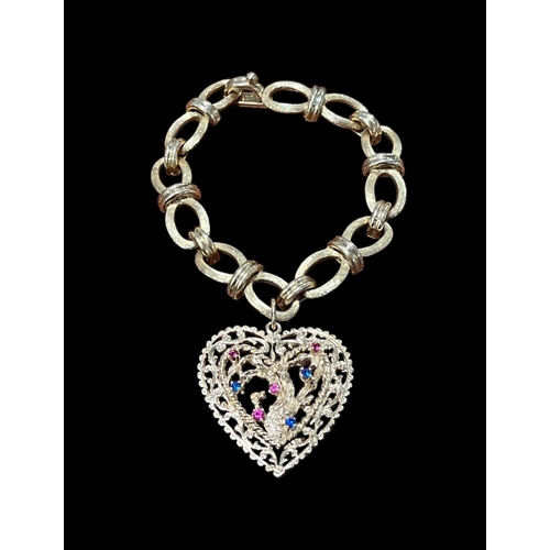 559 - A 14CT GOLD LINK BRACELET with a gold sapphire and ruby heart shaped charm