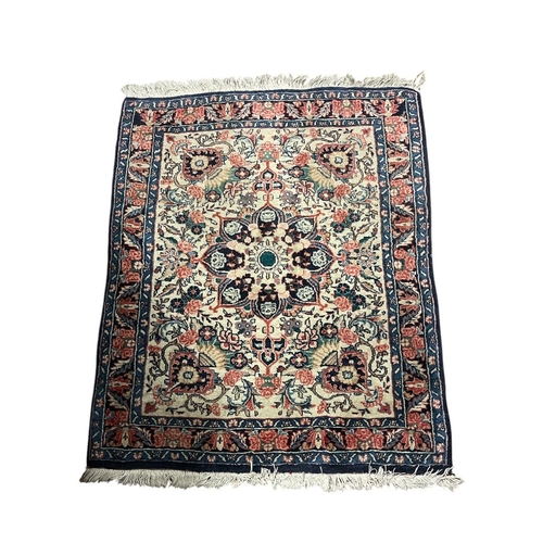 570 - A MASHAD WOOL RUG the beige, light pink and indigo ground with central stylised foliate panel within... 