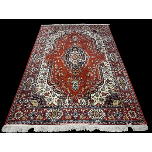 579 - AN ORIENTAL WOOL RUG the rust, indigo, light blue and beige ground with central panel filled with st... 