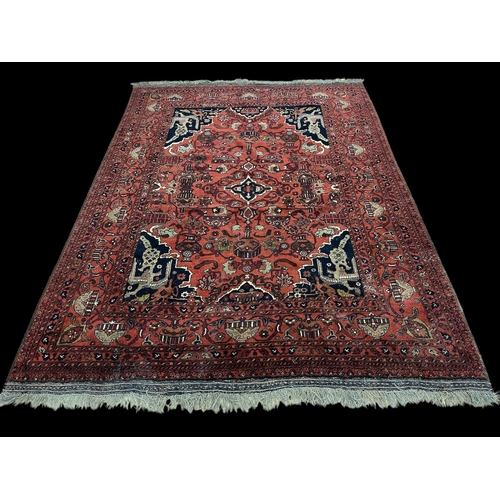 580 - A SAMARKAND WOOL RUG the rust, indigo and beige ground with central panel filled with stylised flowe... 