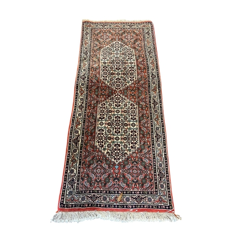 589 - A BIDJAR WOOL RUNNER the red, beige and indigo ground with central diamond shaped panels within a co... 