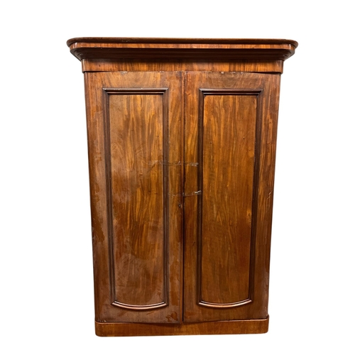 203 - A VICTORIAN MAHOGANY WARDROBE the moulded cornice above a pair of panel doors containing hanging rai... 