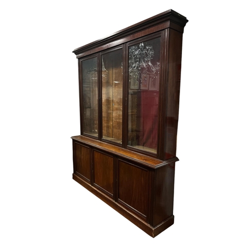 218 - AN EDWARDIAN MAHOGANY LIBRARY BOOKCASE the moulded cornice above three glazed doors with adjustable ... 