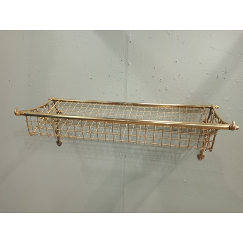 297 - A BRASS WALL MOUNTED LUGGAGE RACK with mesh brass shelf and scroll arms 24cm (h) 75cm (w) 30cm (d)