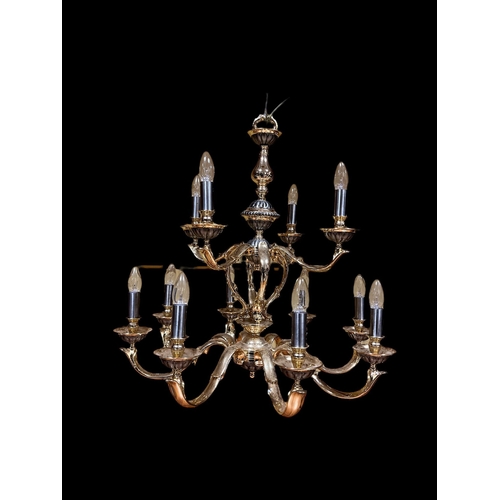 336 - A BRASS TWELVE BRANCH CHANDELIER hung in two registers with scroll arms and lobed drip pans 73cm dro... 