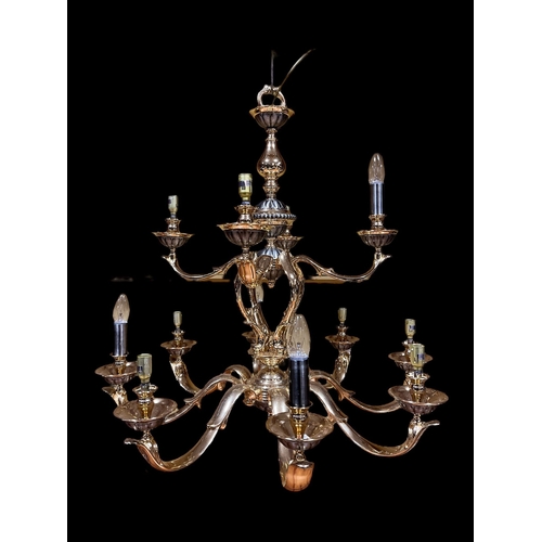 337 - A BRASS TWELVE BRANCH CHANDELIER hung in two registers with scroll arms and lobed drip pans 73cm dro... 