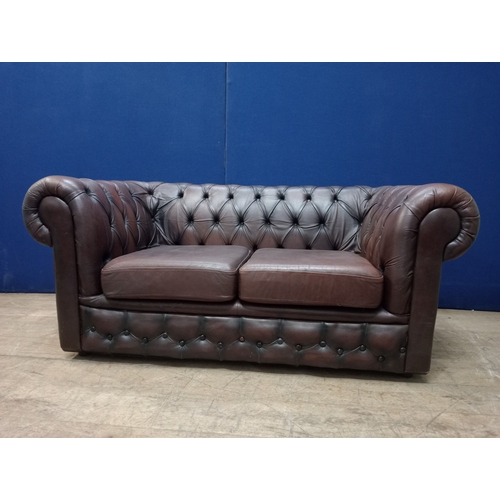 345 - A TWO SEATER BUTTON BACK LIBRARY SETTEE with deep buttoned scroll over back and arms with loose cush... 