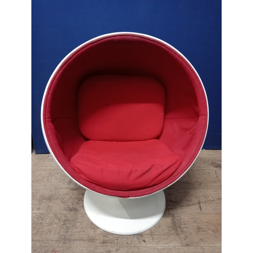 356 - A VINTAGE CHILD’S EGG CHAIR of typical form with red upholstery and loose cushions raised on a circu... 