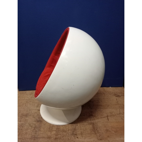 356 - A VINTAGE CHILD’S EGG CHAIR of typical form with red upholstery and loose cushions raised on a circu... 