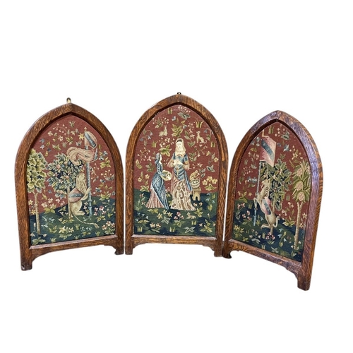 442 - A GOTHIC STYLE OAK FRAME TRIPTYCH FOLDING SCREEN of rectangular arched form with needlework panels 7... 