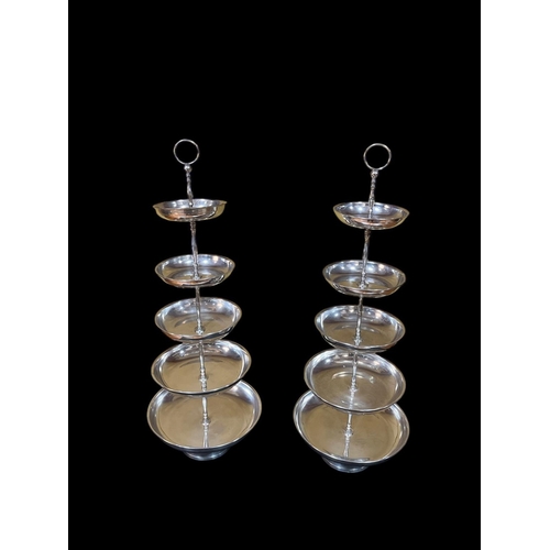 489 - A PAIR OF PLATED FIVE TIER GRADUATED CAKE / FRUIT STANDS with dish shaped bowls joined by a baluster... 