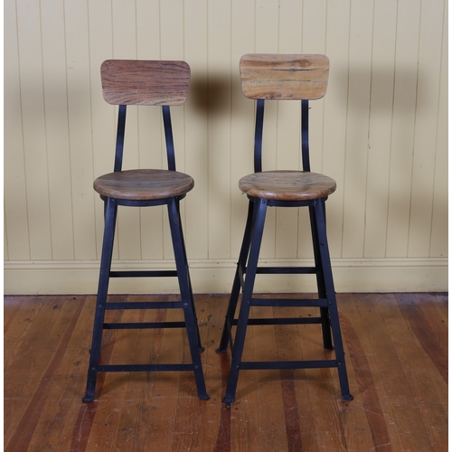 53 - A PAIR OF HARDWOOD AND METAL HIGH STOOLS each with a shaped panel with circular seat on splayed legs... 