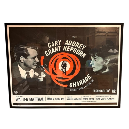 605 - A VINTAGE COLOURED MOVIE POSTER 'Charade Starring Cary Grant, Audrey Hepburn' 75cm (h) x 98cm (w)