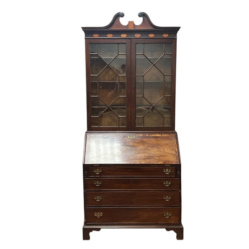 8 - A GEORGIAN MAHOGANY AND SATINWOOD INLAID BUREAU BOOKCASE the swan neck pediment above a pair of astr... 