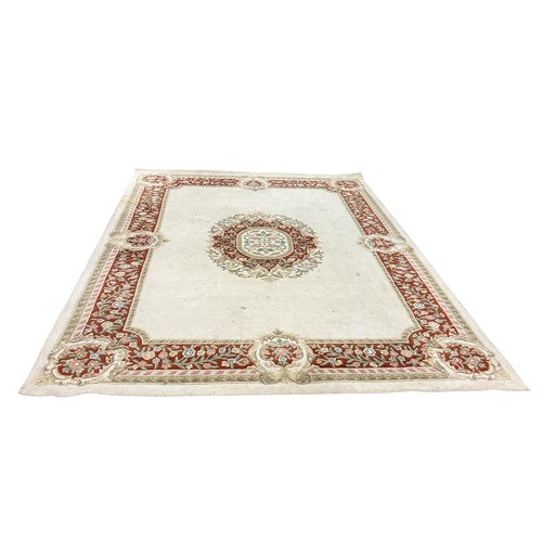 562 - A CHINESE WOOL RUG the beige ground with central floral panel within a conforming border (AF) 360cm ... 