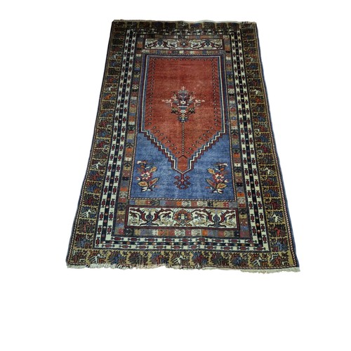 576 - AN ORIENTAL WOOL RUG the light pink and light blue ground with central serrated panel with stylised ... 