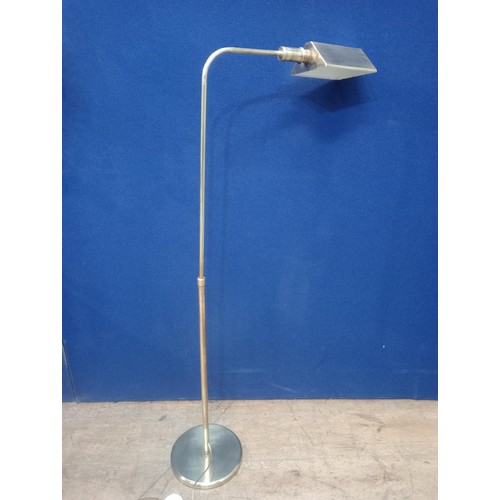 107 - A BRASS READING LAMP with adjustable shade and cylindrical shaped arm raised on a circular foot 75cm... 