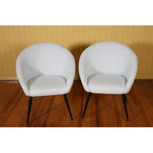 210 - A PAIR OF DESIGNER TUB SHAPED UPHOLSTERED CHAIRS each with a shaped back and seat on cylindrical tap... 