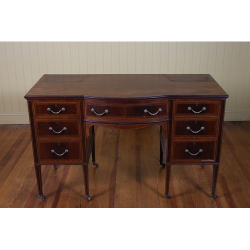 558 - AN EDWARDIAN MAHOGANY AND SATINWOOD INLAID DESK of rectangular bowed outline the shaped top above a ... 