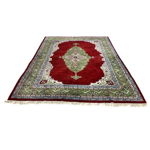 162 - A LARGE ROYAL TABRIZ WOOL RUG the beige, light blue and wine ground with central floral panel within... 