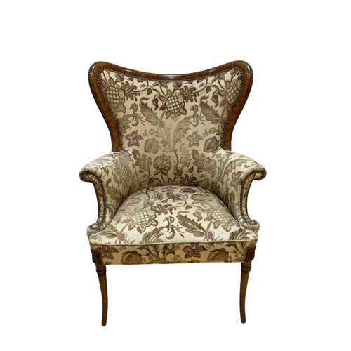 386 - A CONTINENTAL SIMULATED WALNUT AND UPHOLSTERED WING CHAIR the shaped upholstered back and seat with ... 